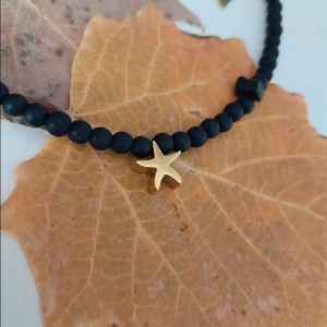 Collar corto de bolas negras y estrella dorada